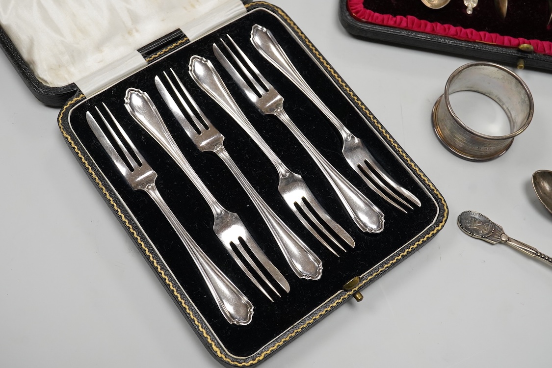 A cased set of six George V silver pastry forks, by Atkin Brothers, Sheffield, 1931, together with a cased set of six Edwardian silver apostle teaspoons and pair of sugar tongs, by Charles Stuart Harris & Sons, London, 1